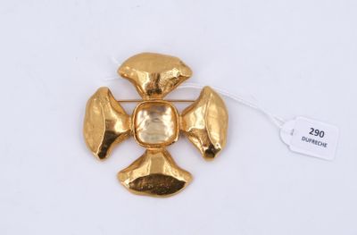 un gros plan d'une broche en or ornée d'une croix