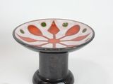 a black and white bowl with a red flower on it