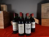 several bottles of wine are lined up on a red table cloth