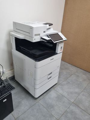 une photo montrant une imprimante et un ordinateur portable dans une pièce