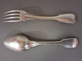 two silver spoons and a fork on a table
