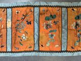 an orange and blue table runner with flowers on it