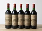 quatre bouteilles de vin sont alignées sur une table en bois