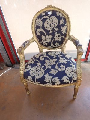 an old chair with a blue and gold upholstered seat
