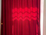 a red curtain hanging over a bed in a room