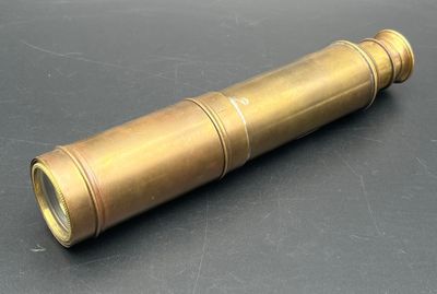 un vieux télescope en laiton posé sur une surface noire