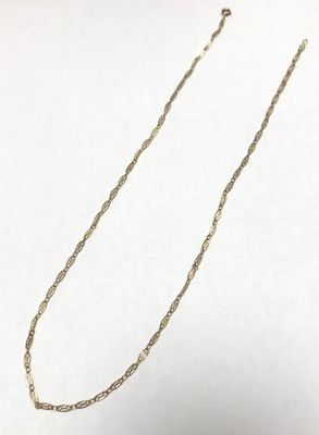 a close up of a necklace on a white surface