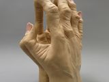 a clay sculpture of a hand holding something in the air