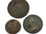 three old coins are sitting next to each other on a white surface