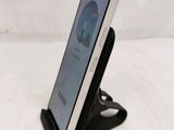 a cell phone that is on a stand on a bed