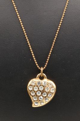 a gold necklace with a heart shaped pendant on a chain