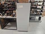 a refrigerator in the middle of a room filled with shoes
