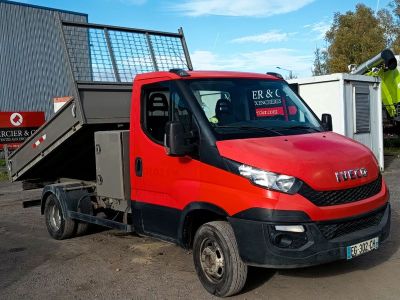 un camion rouge et noir garé devant un immeuble
