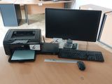 un bureau sur lequel se trouvent un ordinateur, une imprimante, un clavier et une souris