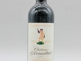 une bouteille de vin rouge posée sur une table blanche