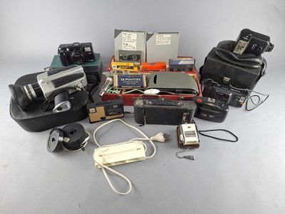 a lot of cameras and other electronic equipment on a table