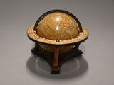 a small globe that is on a stand on a table
