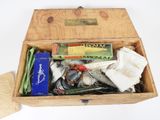 a wooden box filled with assorted fishing items