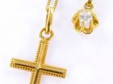 un collier avec une croix en or et un pendentif en forme de fleur en or sur fond blanc