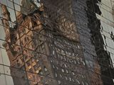 les bâtiments se reflètent dans les vitres d'un immeuble situé de l'autre côté de la rue