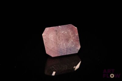 a close up of a pink quartz stone on a black surface