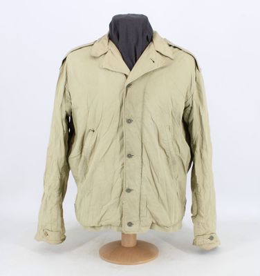 a beige jacket on a mannequin head on a white background