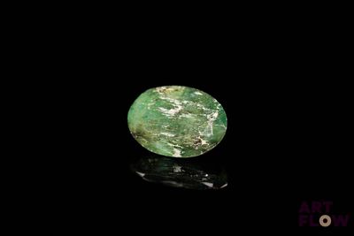 a close up of a green stone on a black surface