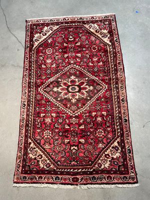 a red rug with a diamond design on it