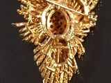 a gold brooch on a black surface