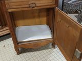a wooden cabinet with a drawer on it in a room