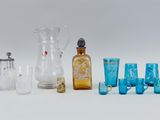 a group of glass items including a pitcher, glass cups, and a glass jug