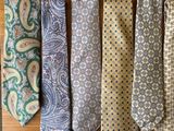 several different colored ties hanging on a wooden rack in a room