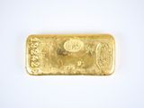 a gold bar on a white surface