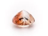 a close up of an orange diamond on a white surface