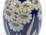 a blue vase with white flowers on it on a white background