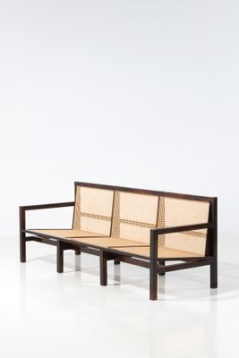 an image of a wooden bench with a woven seat on it