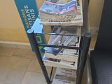 une pile de journaux posée sur un chariot à côté d'une chaise