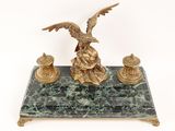 a statue of an eagle sitting on a marble base
