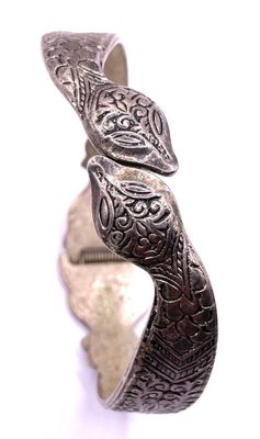 an image of a close up of a silver bracelet on a white surface