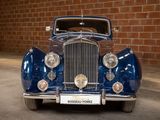 a blue car that is parked in front of a brick wall