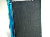a black box with a blue handle sitting on a white surface