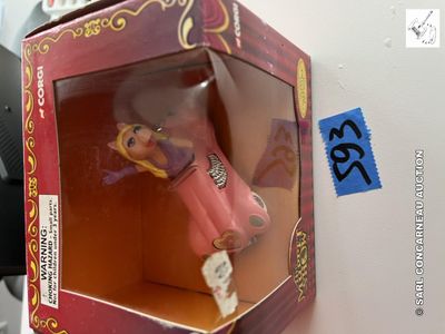 une petite poupée dans une boîte posée sur une table