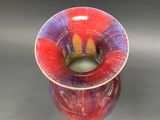 a red and purple vase sitting on a table