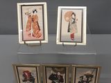 Trois photos encadrées représentant des femmes en kimono sont exposées sur une étagère transparente