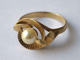 une image représentant une bague en or avec une perle au centre
