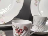 a cup and saucer sitting on a table next to a plate