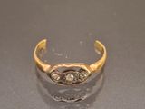 a close up of a gold and diamond ring on a table