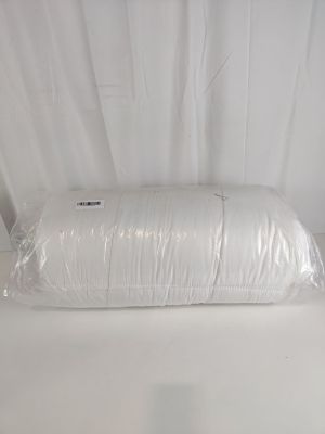 un oreiller blanc enveloppé dans du plastique sur une table