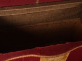 a wooden box with a red and gold design on it