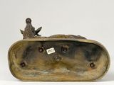 bronze sculpture of a bird sitting on top of a box with a tag on it